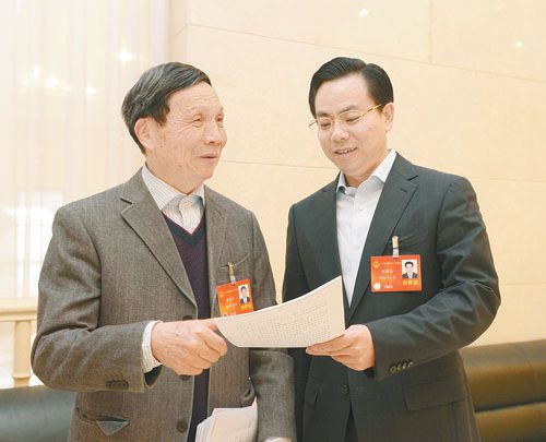 黃伯云代表（左）與劉國忠代表商討完善《關于建立戰略性新興產業國家創新平臺》的建議。 本報記者 張目 攝